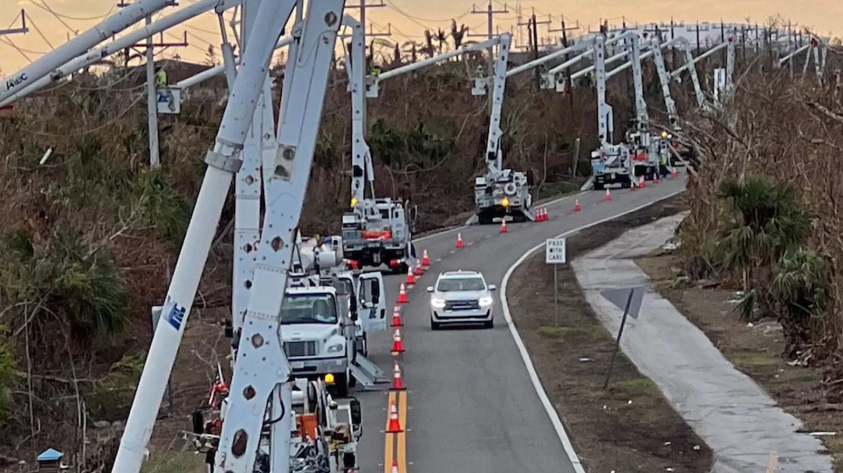 A line of power line workers line the road leading to the Sanibel Causeway