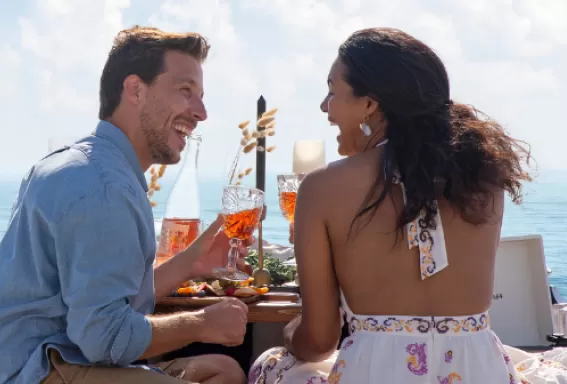 A man and a woman enjoy a beach picnic