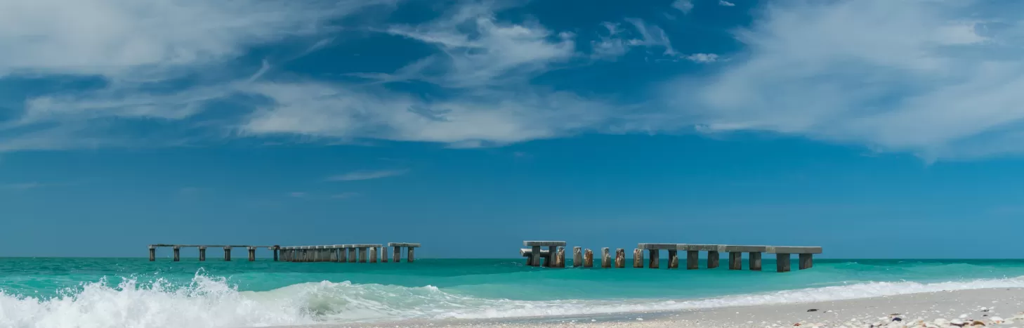 boca grande beach with shells in the foreground and pierhenge in the background