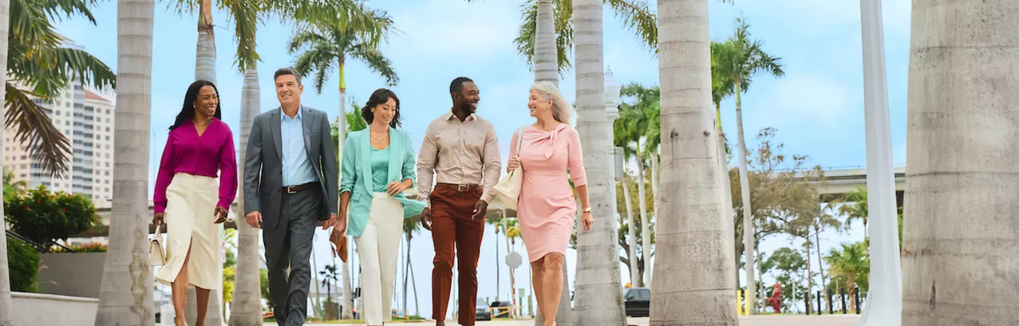 A group of people in professional attire walk downtown